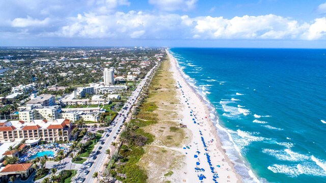 drone / aerial view featuring a beach view and a water view