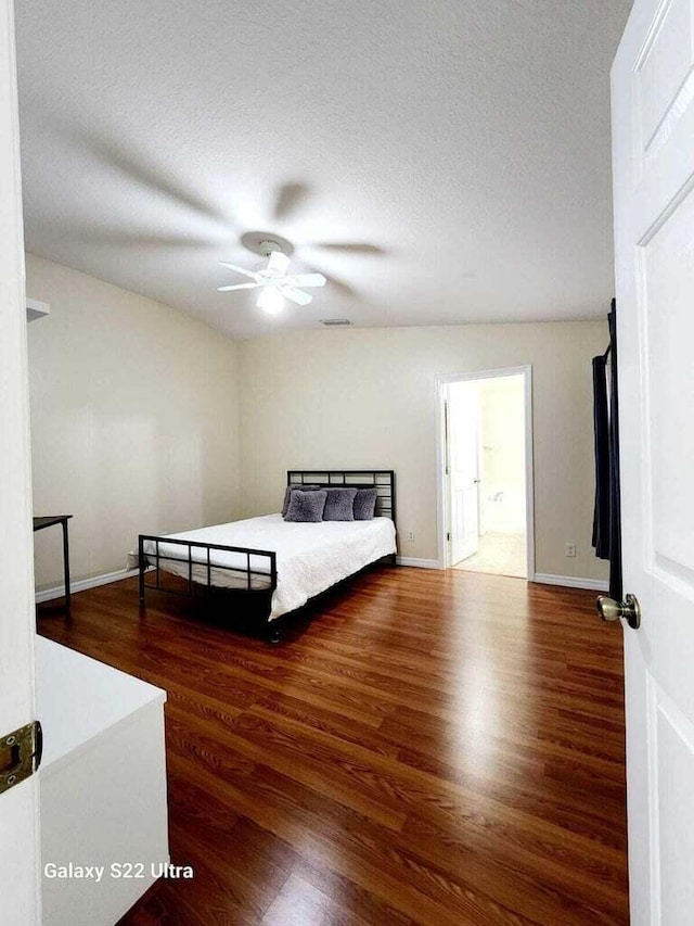 bedroom with dark hardwood / wood-style flooring, ceiling fan, and a textured ceiling