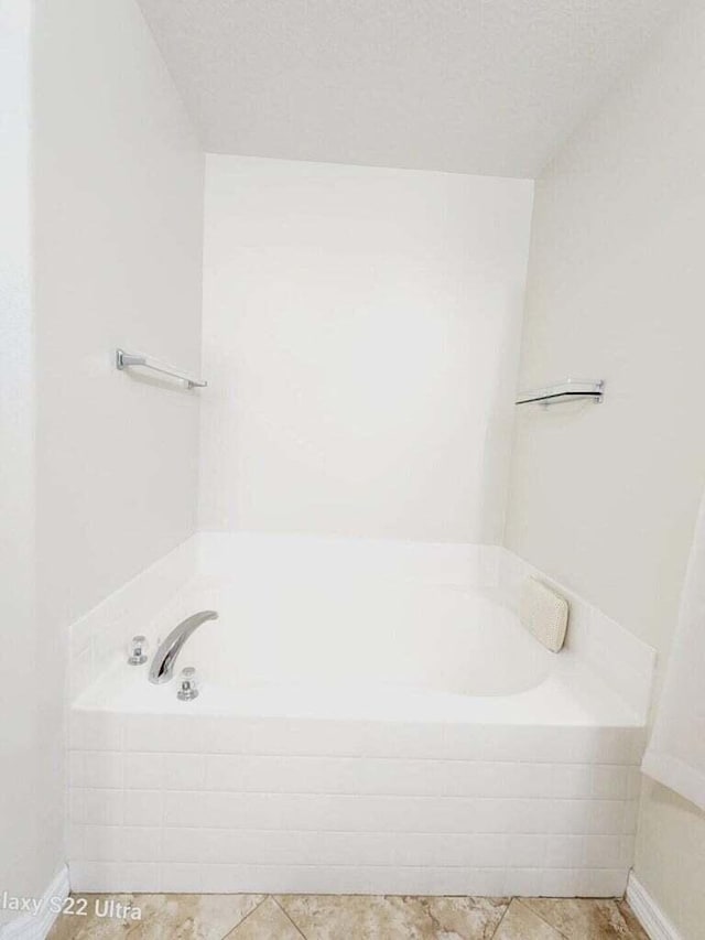 bathroom with a relaxing tiled tub