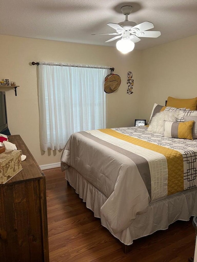 bedroom with dark hardwood / wood-style flooring, a textured ceiling, and ceiling fan