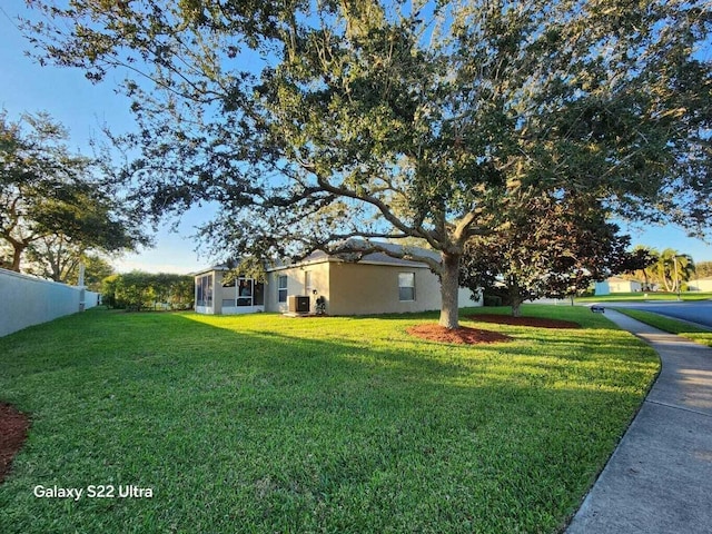 exterior space with a front yard and central air condition unit