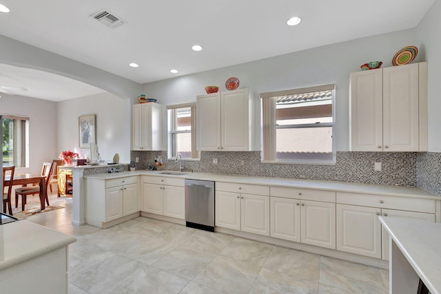 kitchen featuring sink, ceiling fan, white cabinetry, decorative backsplash, and stainless steel dishwasher