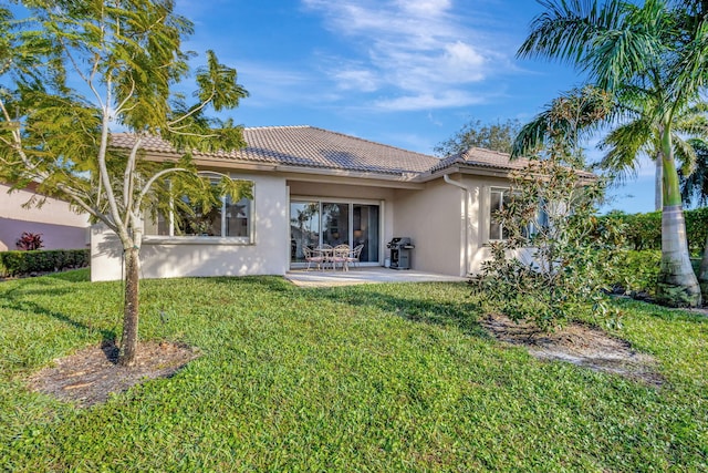 rear view of house with a patio and a lawn