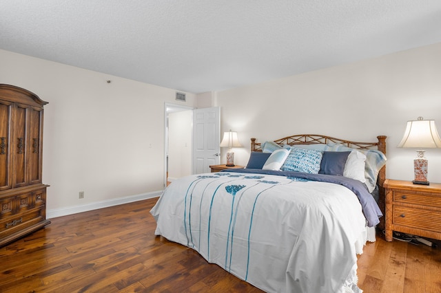 bedroom with dark hardwood / wood-style flooring and a textured ceiling