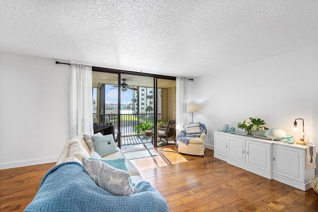 sitting room with hardwood / wood-style flooring, floor to ceiling windows, and a textured ceiling