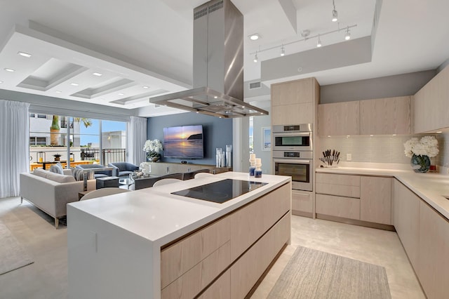 kitchen with a large island with sink, island exhaust hood, stainless steel double oven, and light brown cabinetry