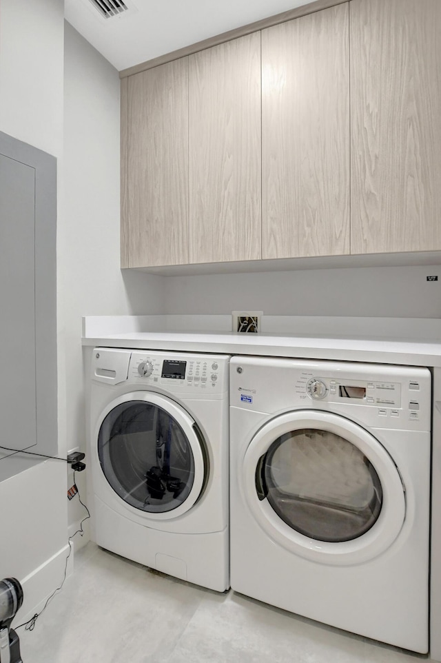 laundry room featuring cabinets and washing machine and dryer