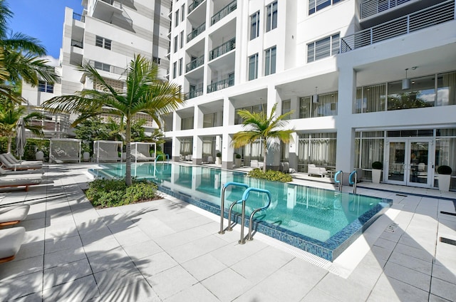 view of swimming pool featuring a patio area and french doors