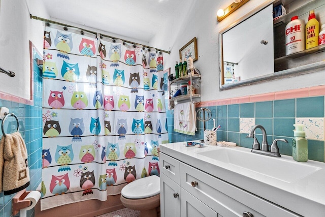 bathroom with vanity, tile walls, and toilet