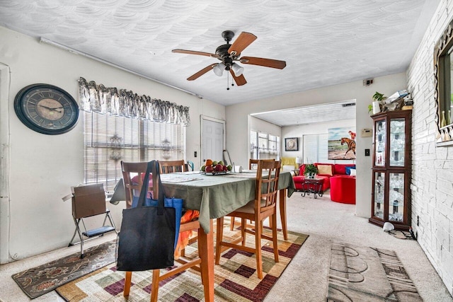 carpeted dining room featuring ceiling fan, a healthy amount of sunlight, and a textured ceiling