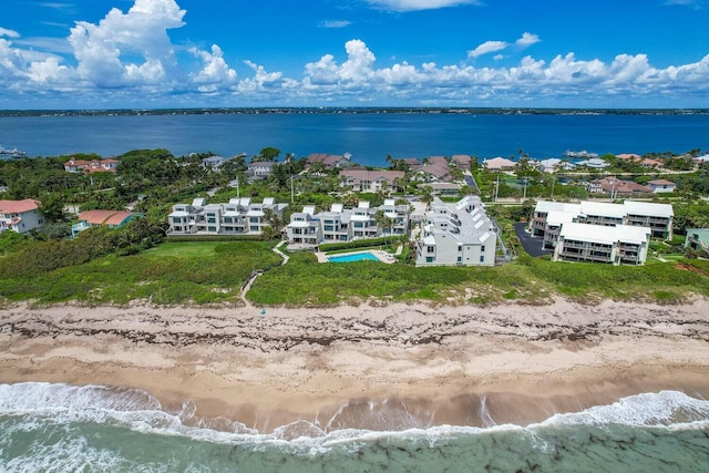 bird's eye view featuring a water view and a beach view