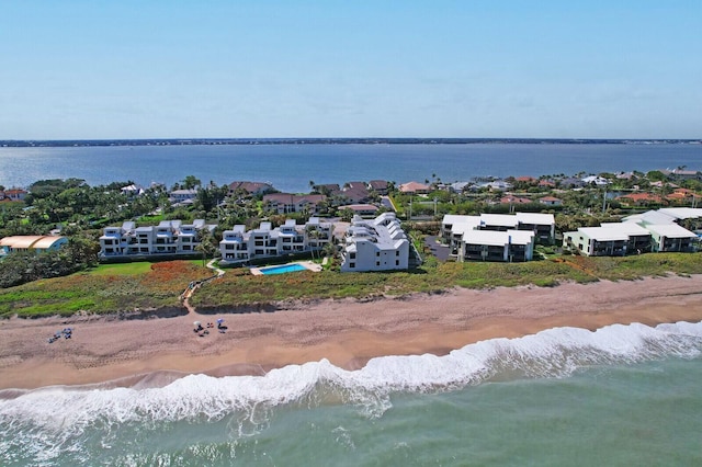 birds eye view of property with a water view and a view of the beach