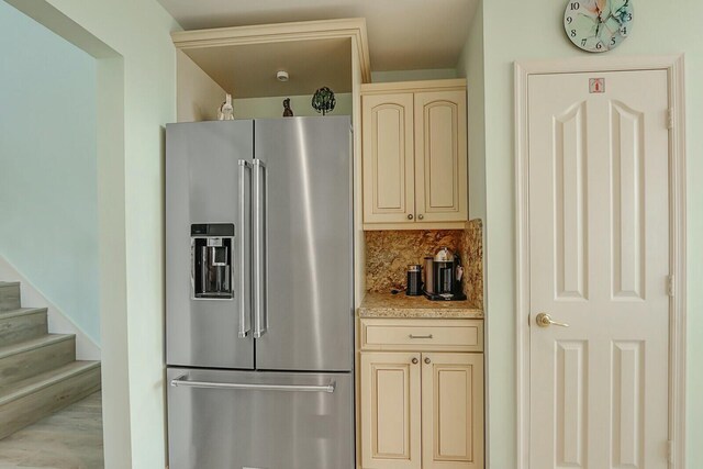 kitchen with light stone counters, stainless steel double oven, open shelves, a kitchen bar, and glass insert cabinets