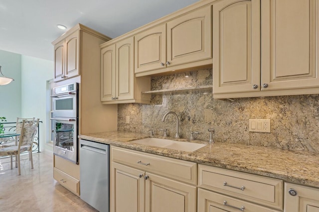 kitchen with sink, stainless steel appliances, tasteful backsplash, light stone countertops, and light brown cabinets