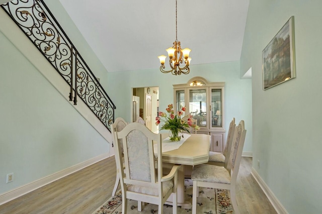 dining room with light hardwood / wood-style flooring and a notable chandelier