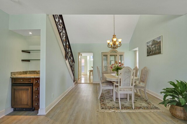 dining space featuring stairs, visible vents, wood finished floors, and ceiling fan with notable chandelier