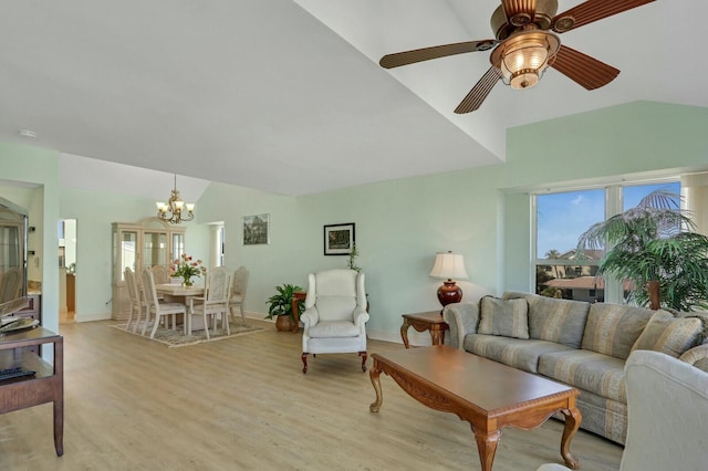 living room with lofted ceiling, ceiling fan with notable chandelier, and light hardwood / wood-style floors