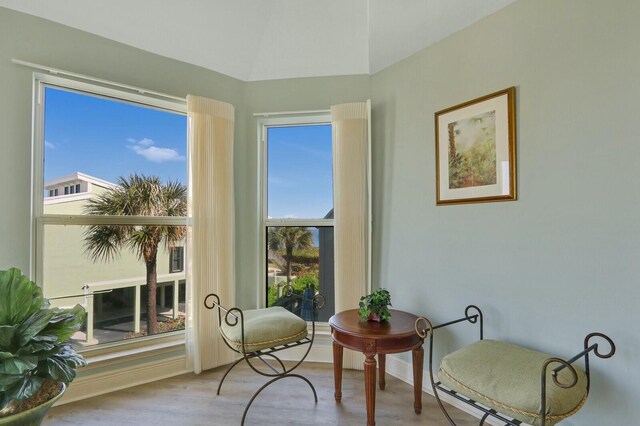 living room featuring vaulted ceiling, light wood finished floors, a ceiling fan, and baseboards