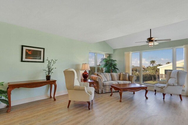 living room with light wood finished floors, lofted ceiling, visible vents, a ceiling fan, and baseboards