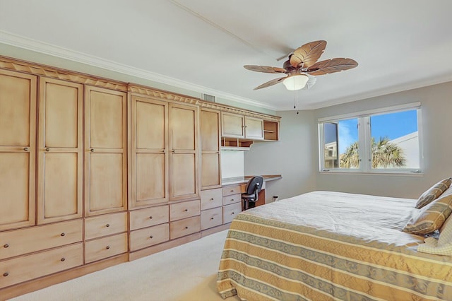 bedroom with light colored carpet, built in desk, ornamental molding, and ceiling fan