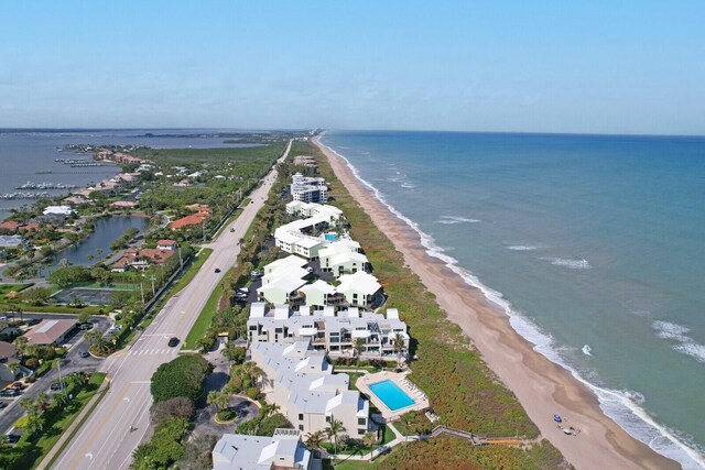 birds eye view of property with a water view and a beach view