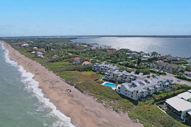 drone / aerial view featuring a water view, a residential view, and a view of the beach