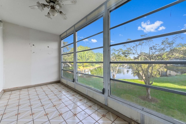 unfurnished sunroom featuring ceiling fan and a water view