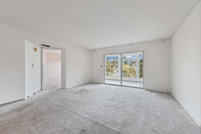 carpeted empty room featuring a textured ceiling