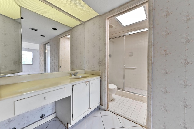 bathroom with vanity, a shower with door, tile patterned floors, and toilet