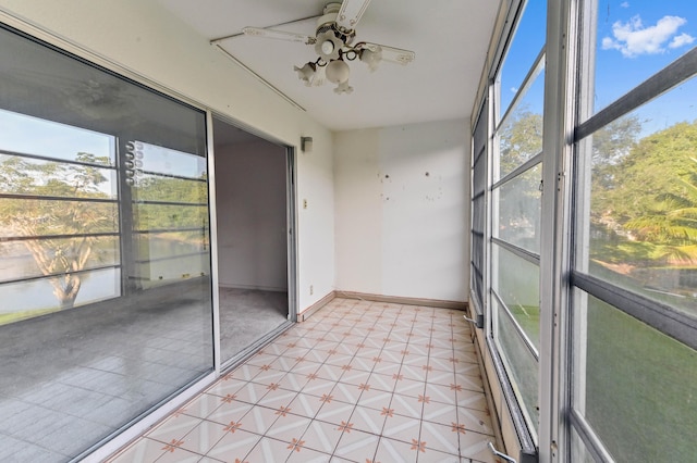 unfurnished sunroom featuring ceiling fan