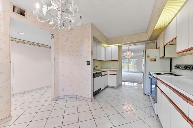 kitchen featuring light tile patterned floors, white appliances, white cabinetry, hanging light fixtures, and a notable chandelier