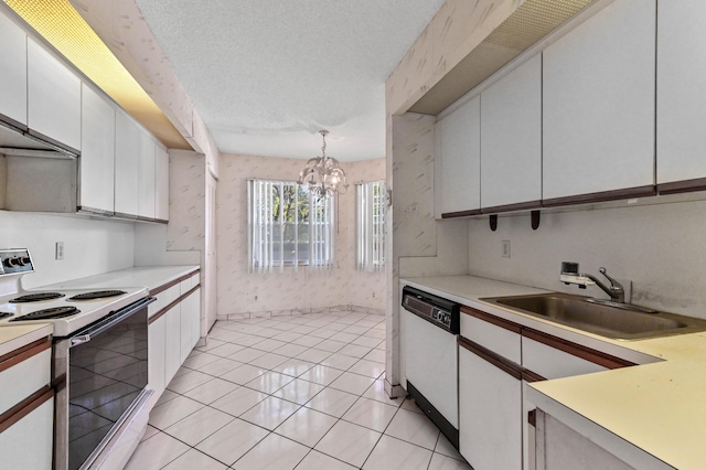 kitchen featuring pendant lighting, sink, white appliances, a textured ceiling, and white cabinets