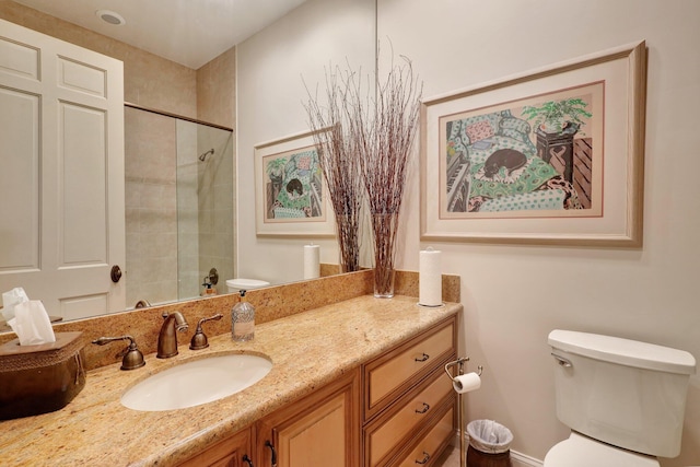 bathroom with vanity, tiled shower, and toilet