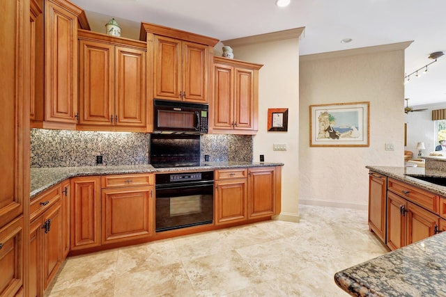 kitchen with stone countertops, sink, decorative backsplash, and black appliances