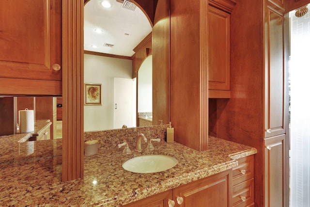 bathroom with ornamental molding and vanity