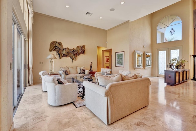 living room with a high ceiling and ornamental molding