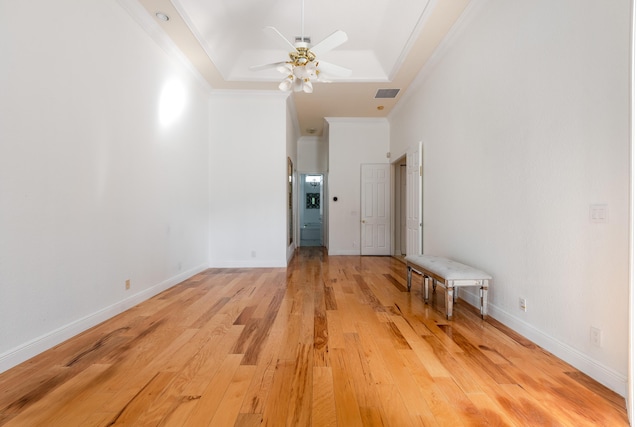 unfurnished room featuring ceiling fan, ornamental molding, a tray ceiling, and light hardwood / wood-style flooring