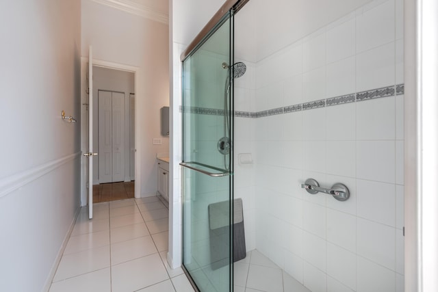 bathroom with a shower with door, crown molding, tile patterned flooring, and vanity