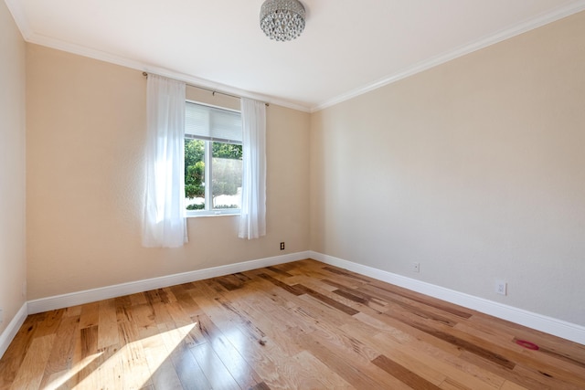 spare room featuring crown molding and light hardwood / wood-style flooring