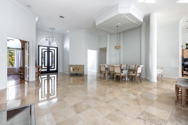 foyer entrance featuring a high ceiling, ornamental molding, a notable chandelier, and french doors