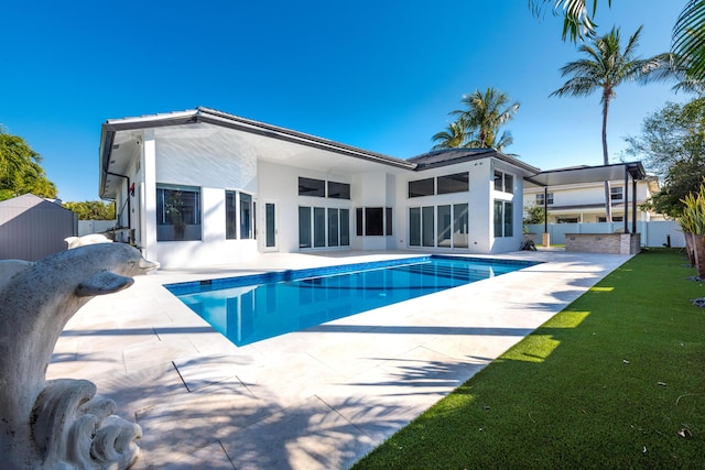 rear view of property with a yard and a patio