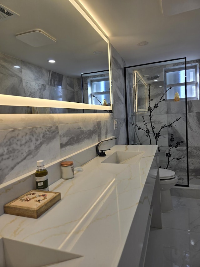 bathroom with vanity, toilet, an enclosed shower, and tile walls