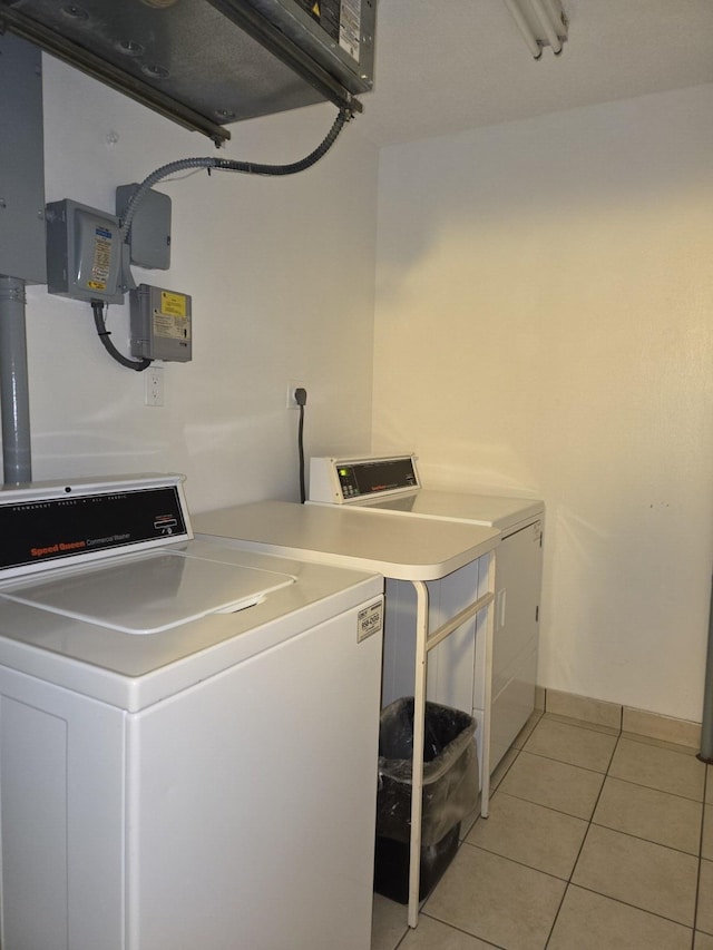 laundry room featuring separate washer and dryer and light tile patterned floors