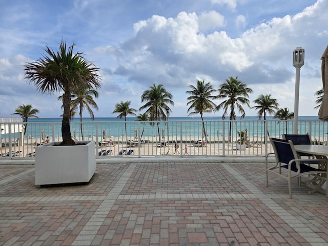 view of swimming pool with a water view and a view of the beach