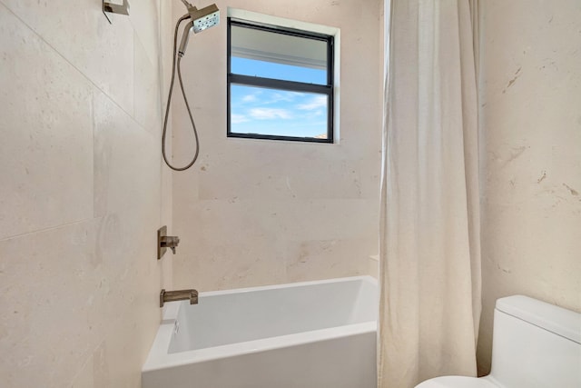 bathroom featuring shower / bath combo and toilet