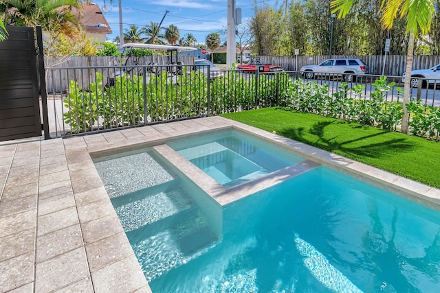 view of swimming pool with an in ground hot tub and a lawn