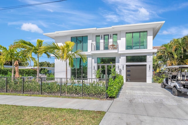 contemporary house featuring a garage and a balcony