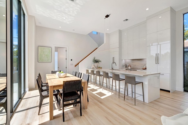 dining room featuring sink and light hardwood / wood-style flooring