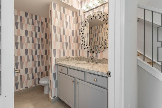 bathroom with tile patterned flooring, vanity, and toilet