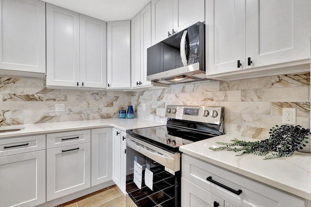 kitchen with stainless steel electric range and white cabinets